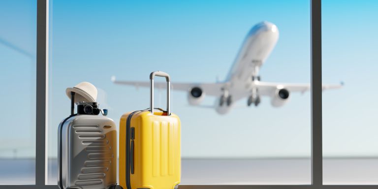 2 Koffer am Flughafen mit einem Flugzeug im Hintergrund