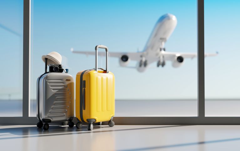 2 Koffer am Flughafen mit einem Flugzeug im Hintergrund