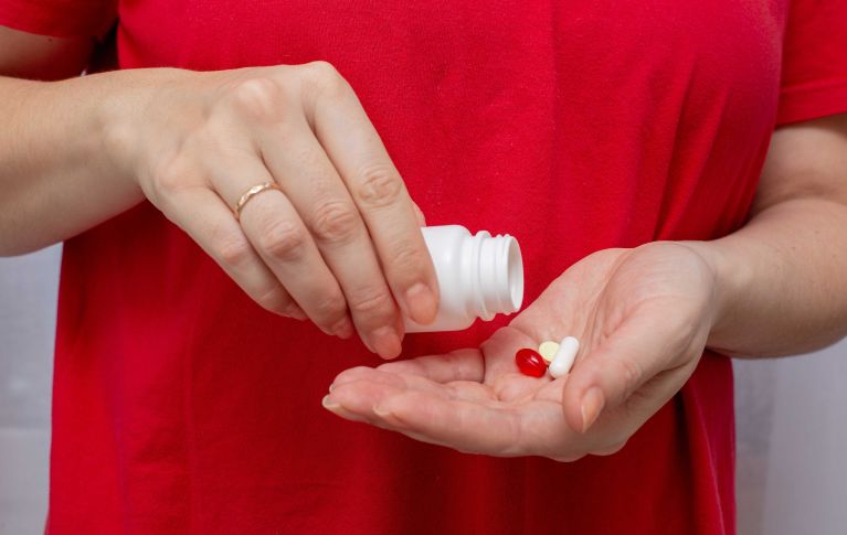 Eine Person schüttet Pillen ih ihre Handfläche